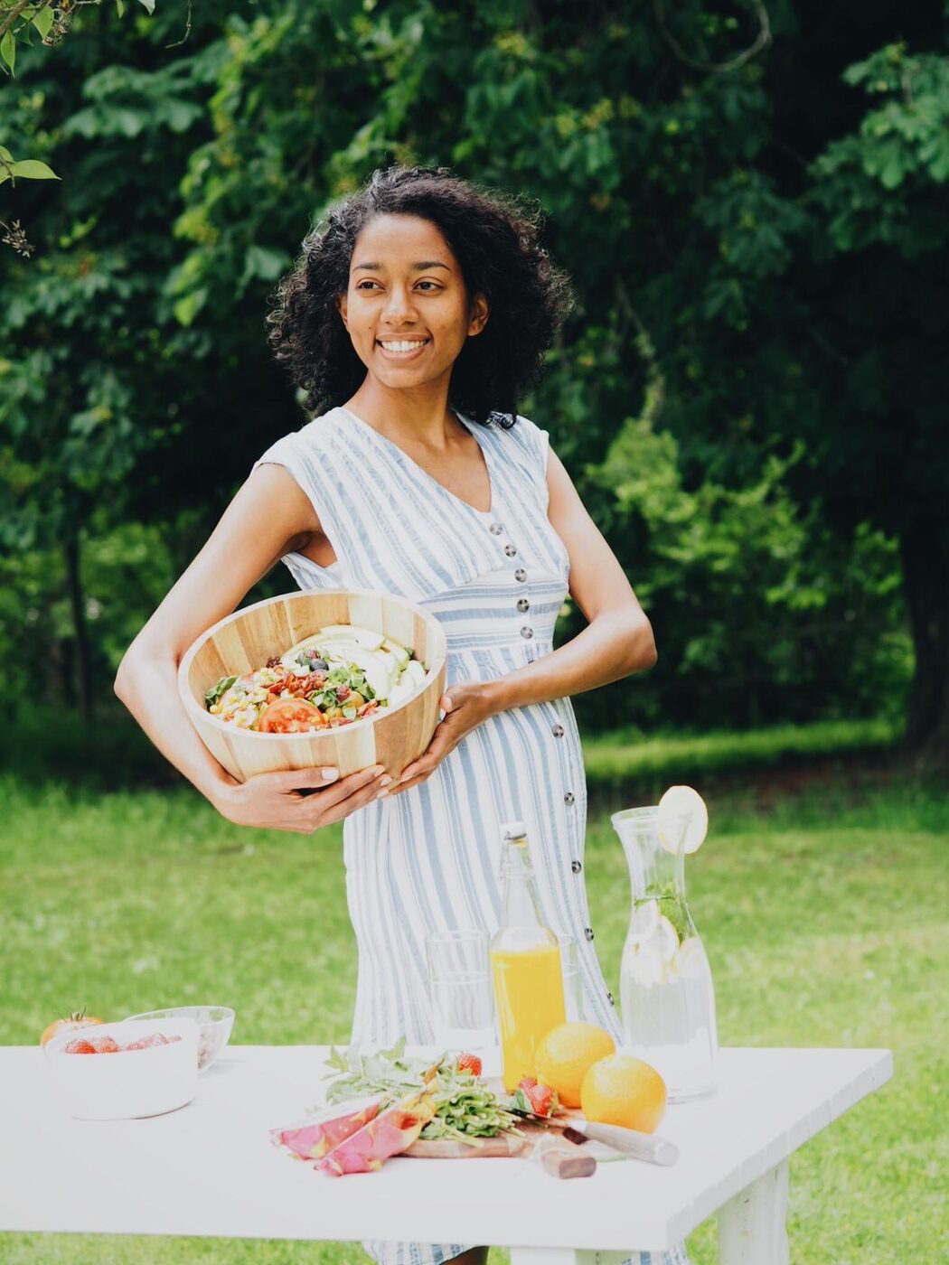 Telma holding a bowl of fresh plant-based food outdoors